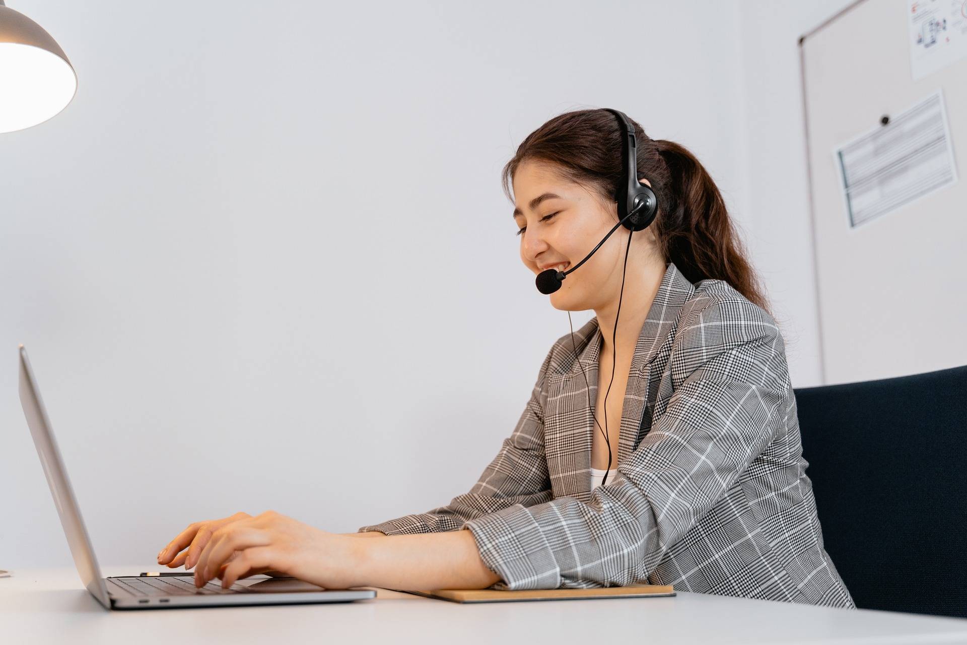 Woman on laptop with a headset on