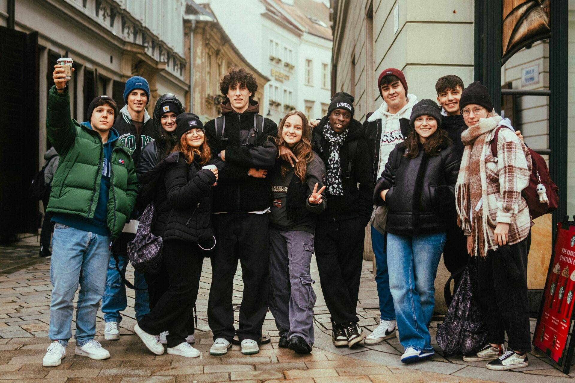 A group of young people standing next to each other in the street.