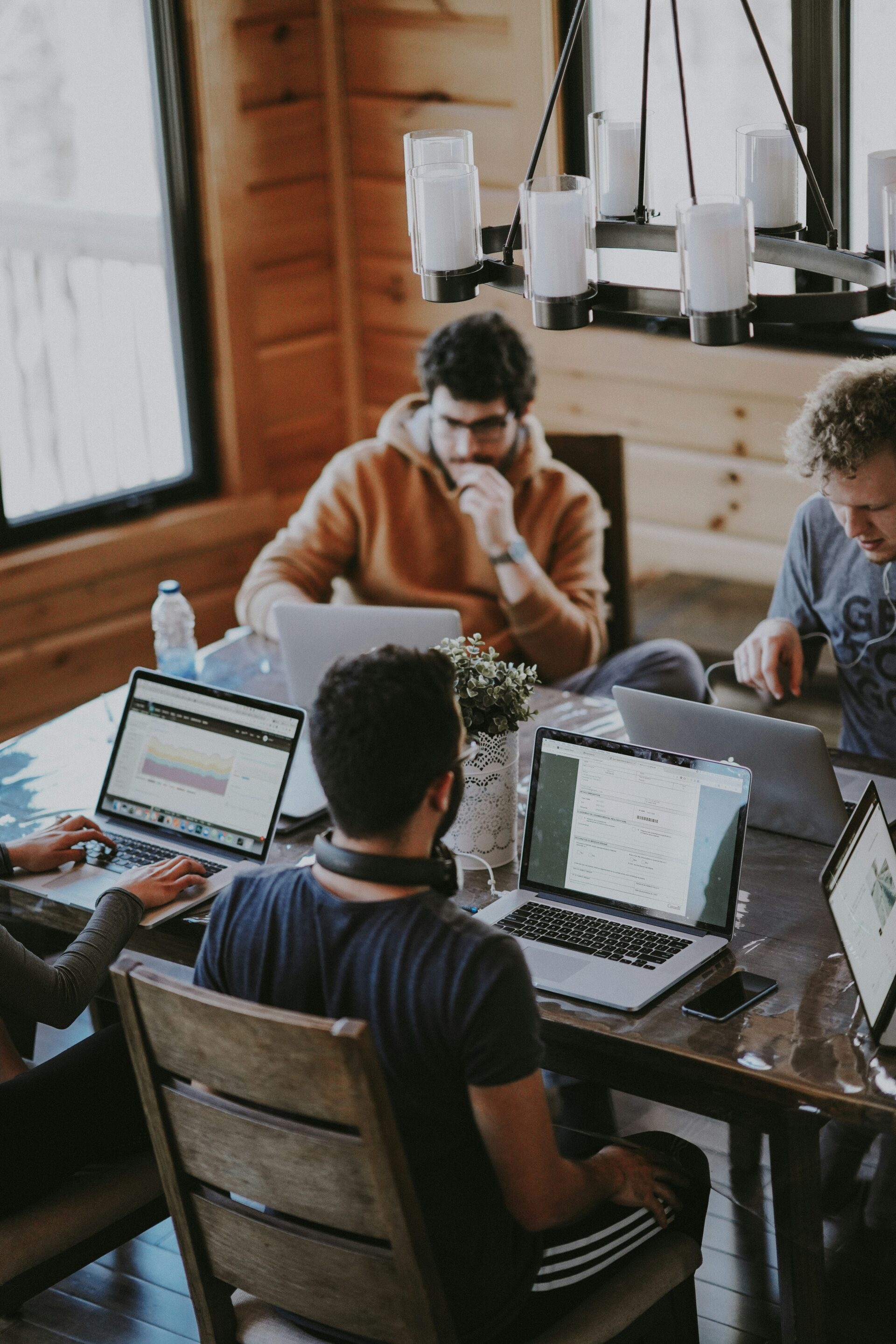 Some of the Unsplash team working together, whilst sat at desks in front of laptops.