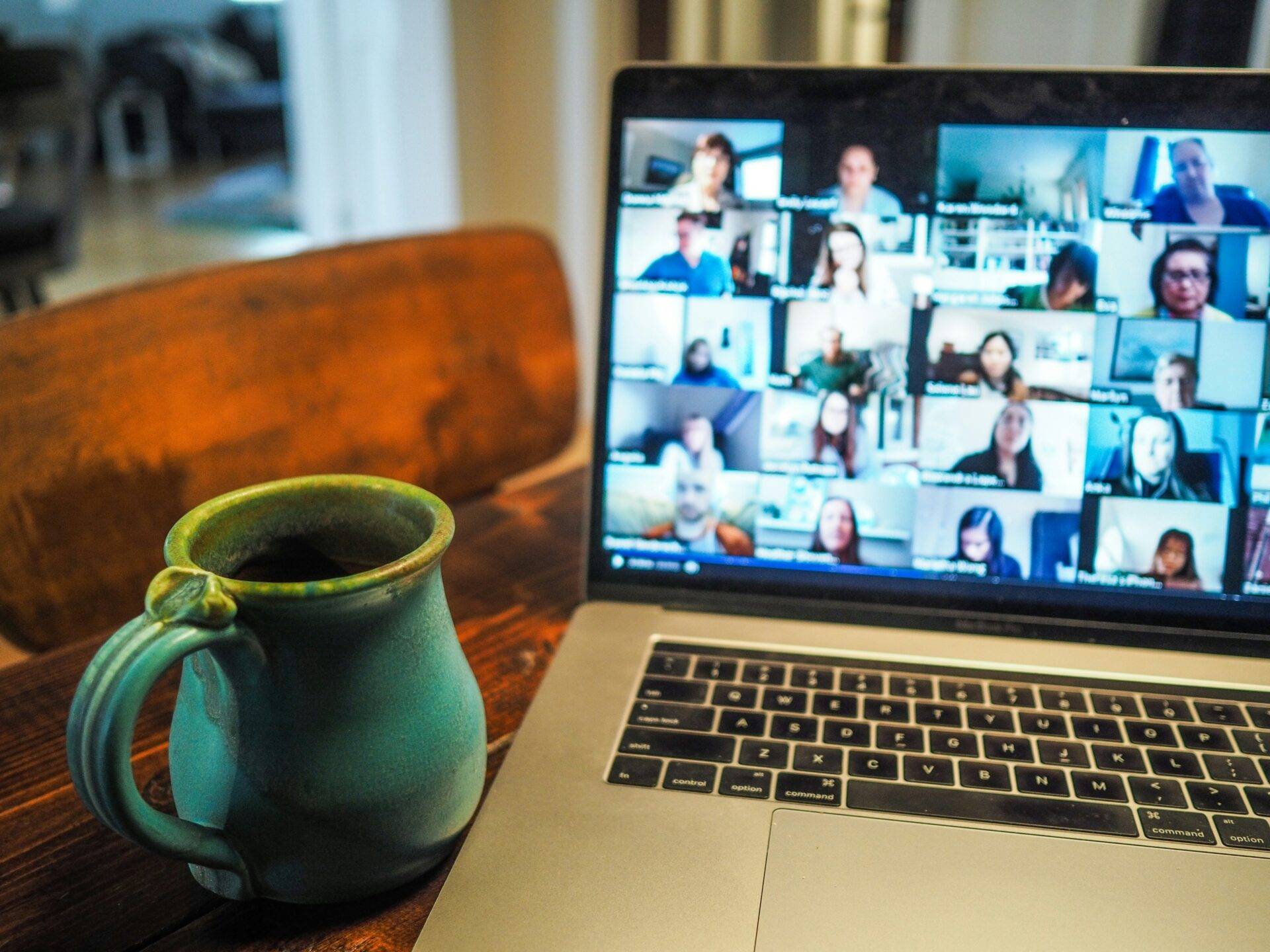 Macbook pro displaying group of people in virtual meeting.