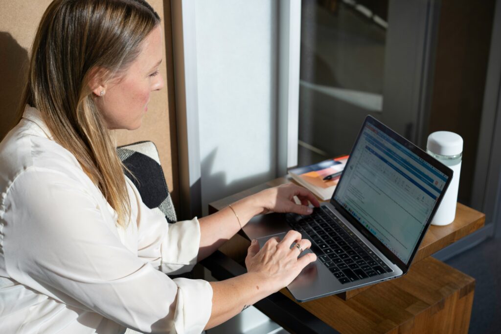 A salesperson working in an office at a laptop in the sun