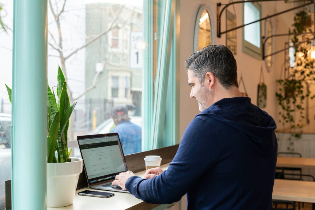 A salesperson checking a laptop in a coffee shop