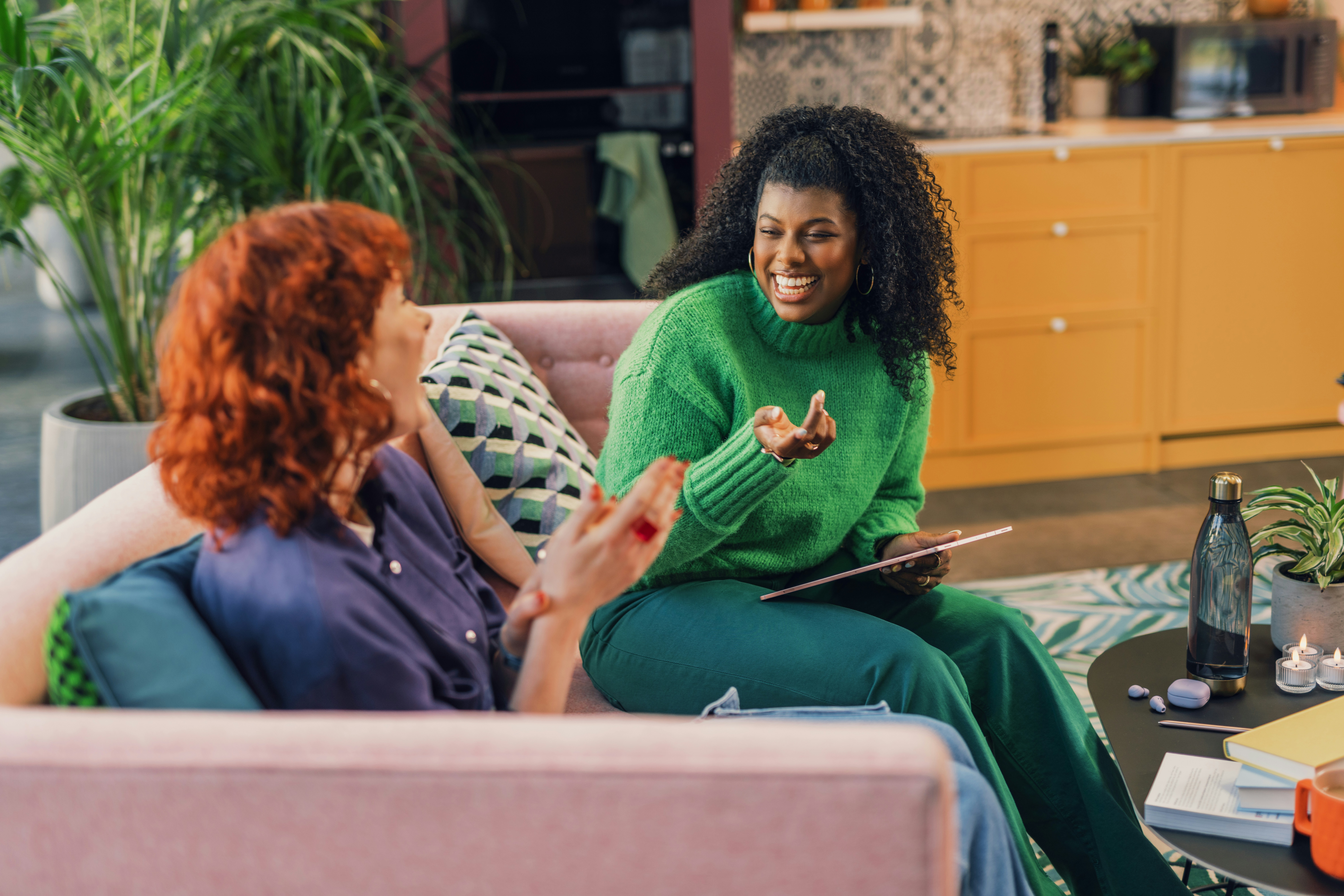 Two women sitting on a sofa having a friendly conversation
