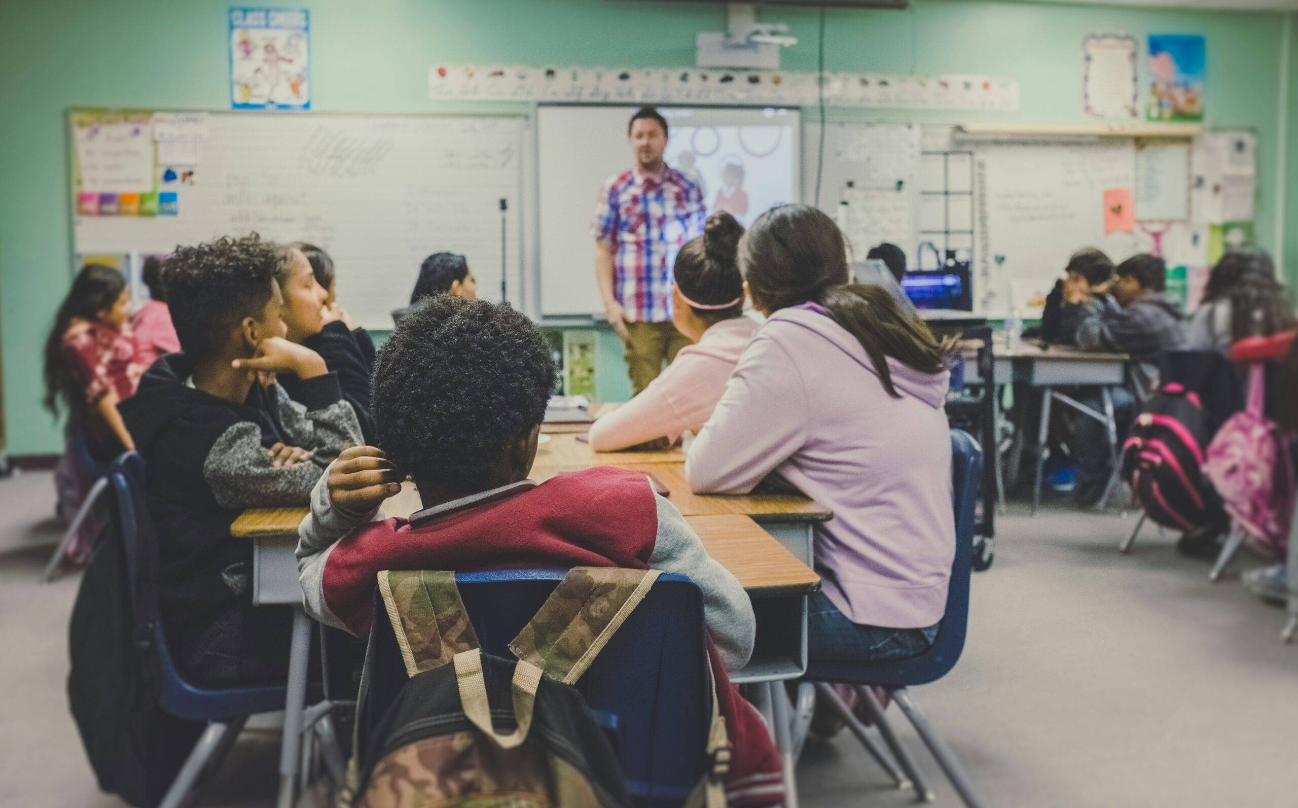 Person teaching classroom of children. 